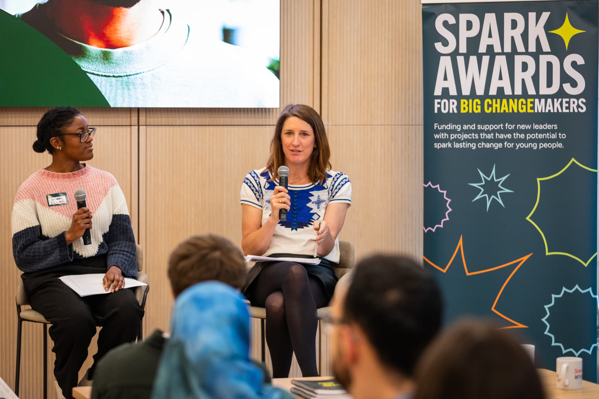 Two people speaking at the Sparks Award Launch