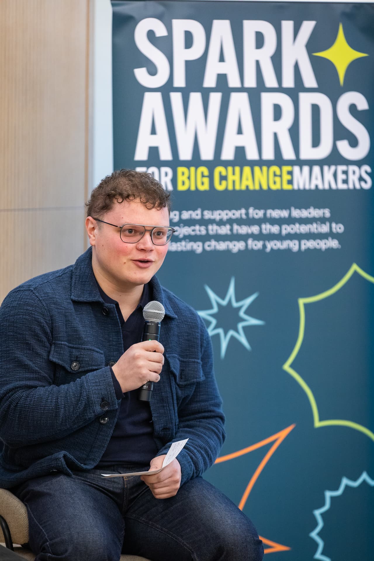 A young man speaking at the Spark Awards Event